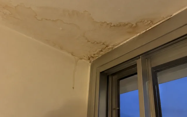 Water stain across the ceiling corner beside the balcony door